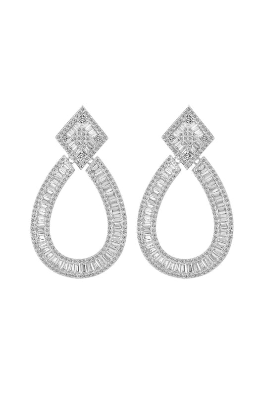 A pair of SONYA EARRINGS by LUCKY13 featuring a diamond-shaped top with a larger teardrop-shaped design hanging below. Both shapes are adorned with numerous small, sparkling diamonds set in 925 sterling silver, creating a luxurious and elegant statement look.