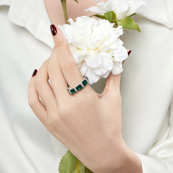 woman wearing a sparkling eternity ring set with green cubic zirconia stones.