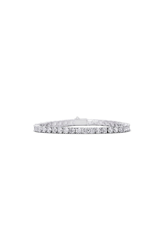 The CRYSTAL CLEAR BRACELET by LUCKY13 is a delicate and classic piece that features a continuous line of sparkling round-cut cubic zirconia stones set in a thin band with 14K Gold plating. This elegant and sophisticated bracelet is beautifully displayed against a white background.