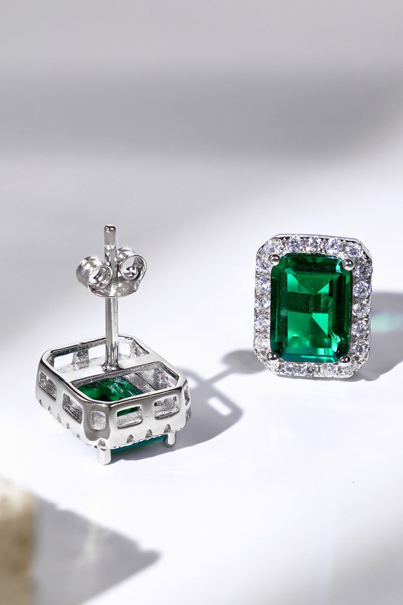 A pair of emerald green solitaire stud earrings set with emerald cut zirconia handcrafted in 925 sterling silver by Lucky13 Jewelry