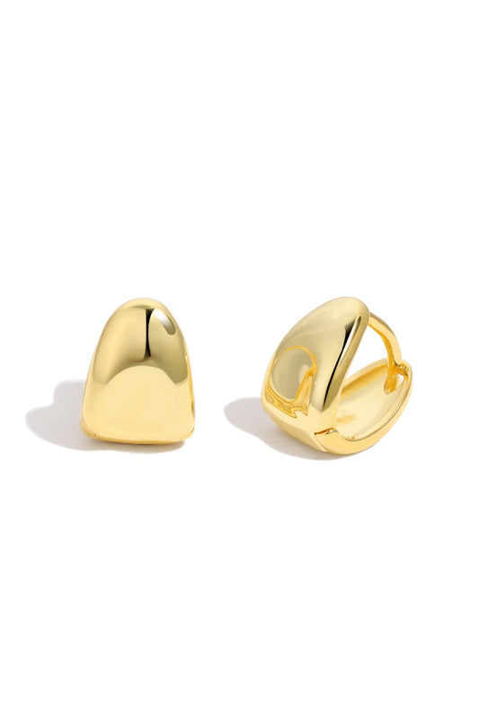 A pair of lightweight gold PUFFY HUGGIES by LUCKY13 is shown. The earrings have a smooth, shiny surface with a rounded, slightly irregular shape. One earring is closed, while the other is open to display the comfortable clip-on mechanism. Both earrings cast a soft shadow on the white background.